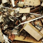 A chaotic pile of discarded wooden furniture and chairs seen from above.
