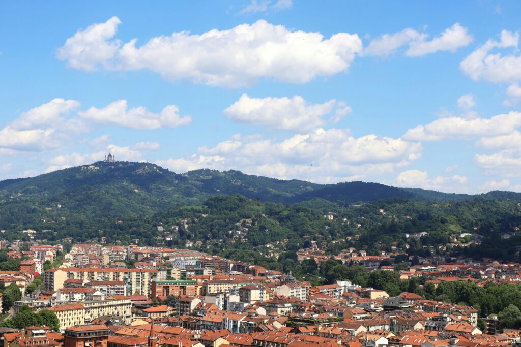 A breathtaking aerial view of Turin, Italy, showcasing the vibrant cityscape and lush green hills.