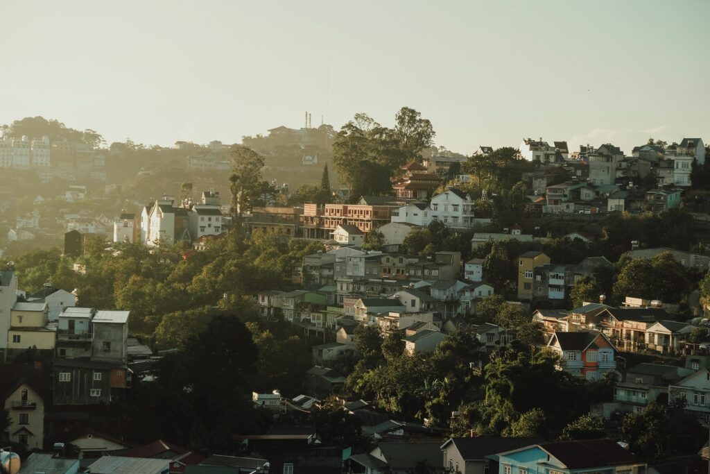 Captivating aerial view of a hillside town with dense housing and lush greenery, captured at dusk.