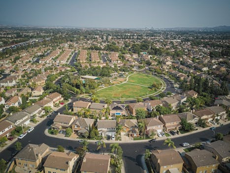 Drone aerial view of a spacious suburban neighborhood with a central park area.